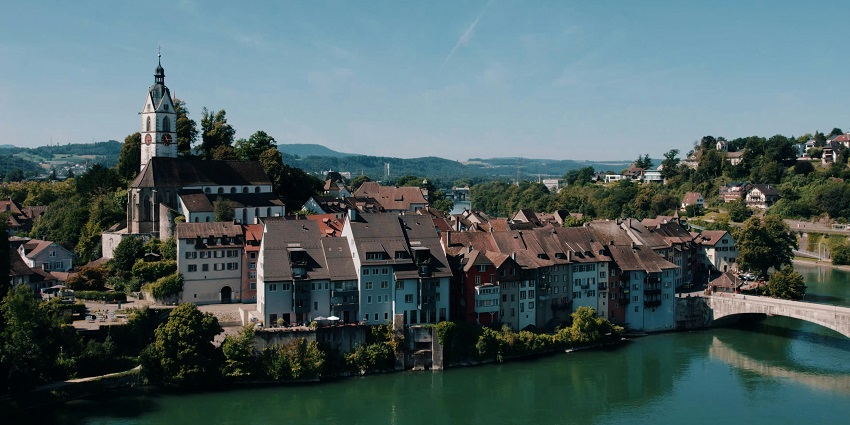 Picturesque Swiss city with lakeside views, mountains, and historic bridges