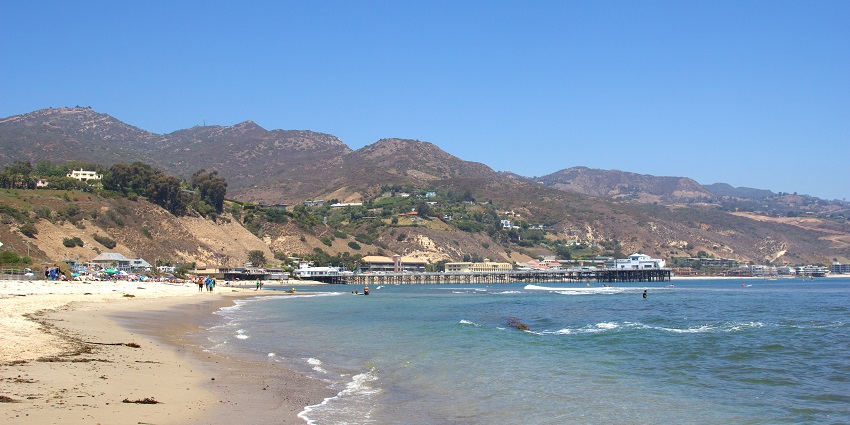 Panoramic view of the downhill sandy beach of Malibu and pier with clean blue water