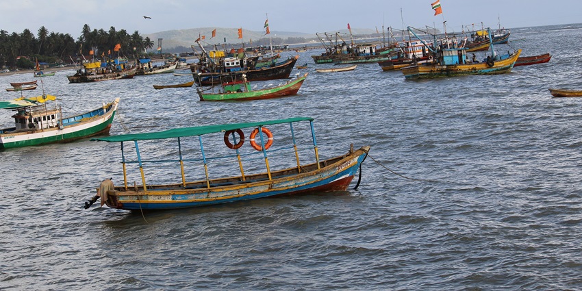 Image of Malvan Beach with boats floating near the port - clear blue sky and clear water