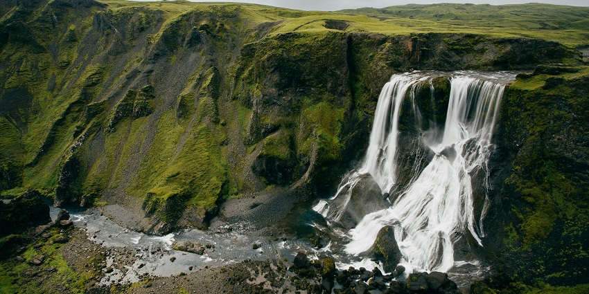 Serene waterfall flowing gently over rocks in picturesque surroundings