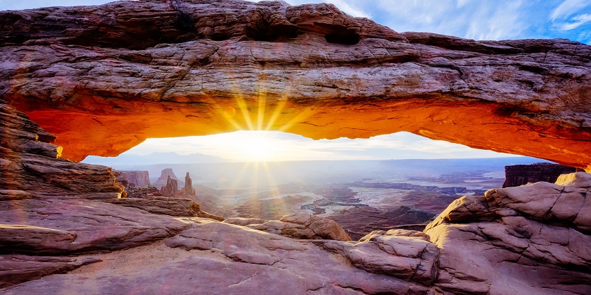 A vibrant sunrise through the Mesa Arch.