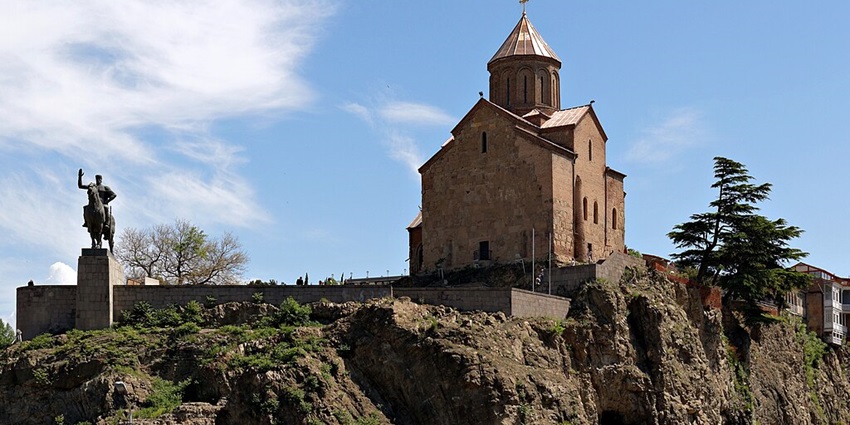 Metekhi Church, a historic church overlooking Tbilisi, with scenic river and city views.
