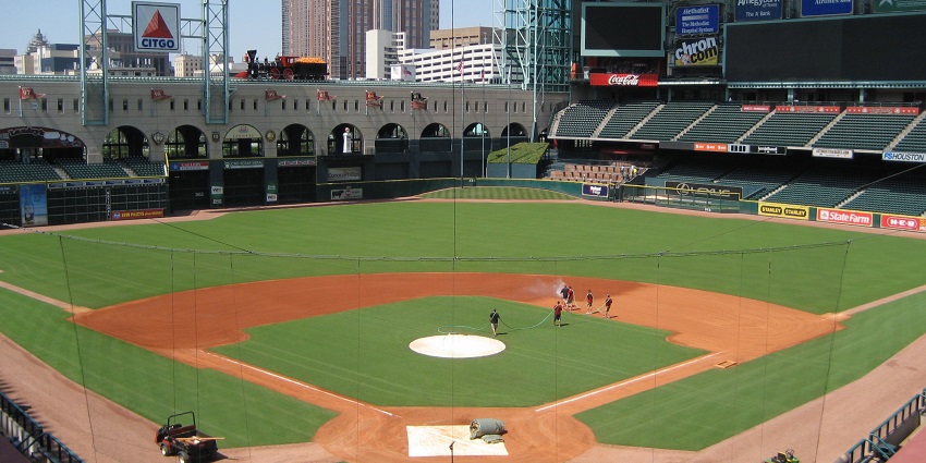 Minute Maid Park with a baseball field, people walking on the ground and multiple stands