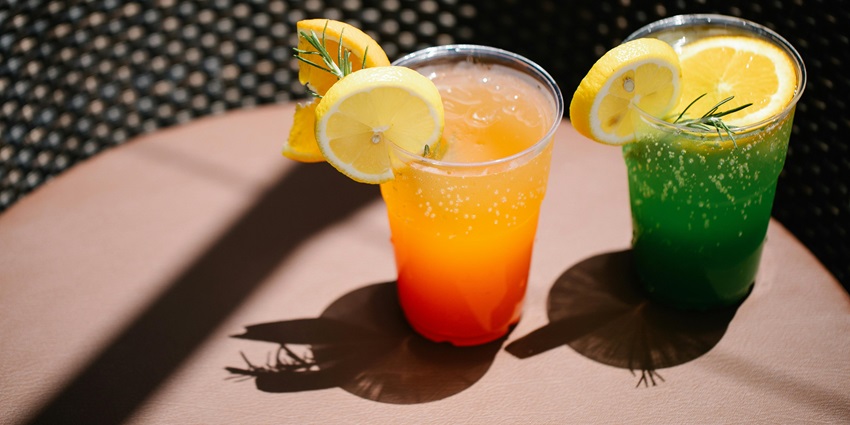 A picture of one cocktail is prepared by a barman who pours a shot of liquor into the cocktail