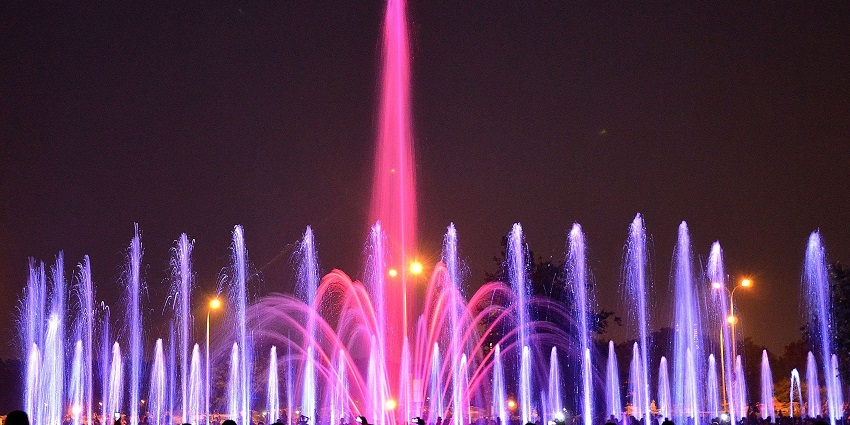 Wroclaw multimedia fountain with colorful vibrant lighting and shadows of people