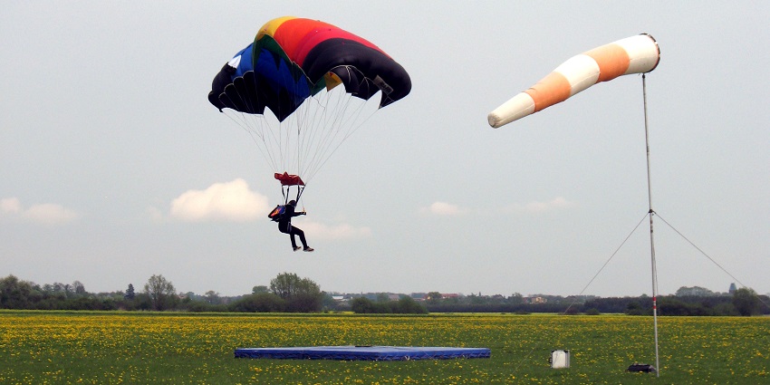 An individual landing with the help of a parachute while skydiving in Melbourne