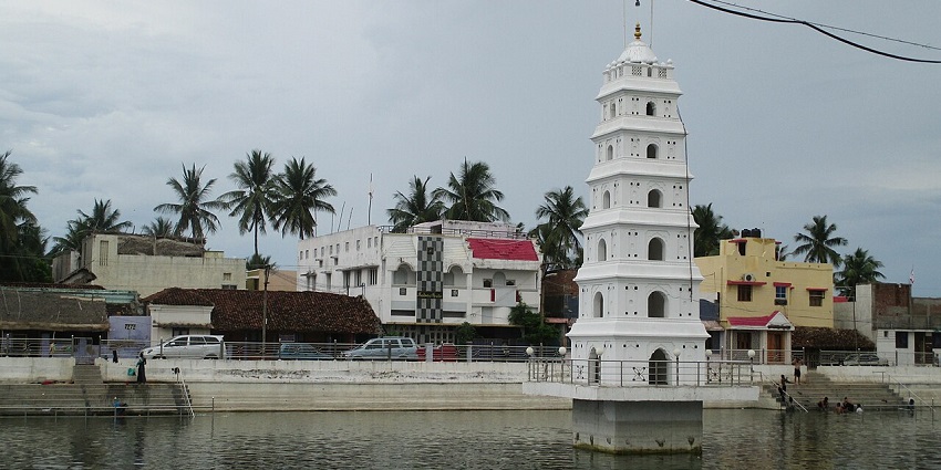A distant view of a historical dargah in Karaikal, with a sacred water tank in front