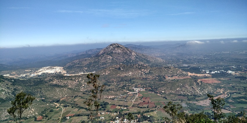 An aerial view of the Nandi Hills featuring a quaint town and majestic mountains.