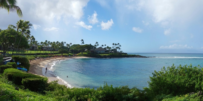 Sunset view at Napili Bay, Maui, with vibrant skies reflecting over the calm ocean.