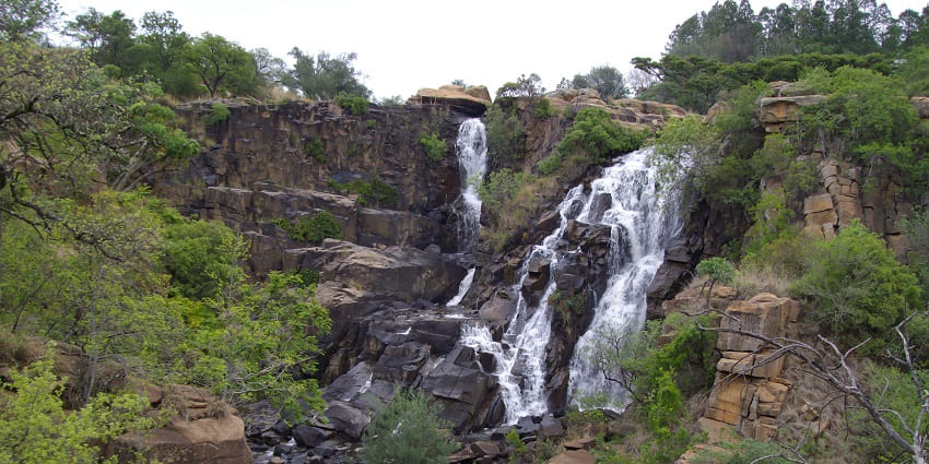 A view of Ncandu Waterfall surrounded by forest area.