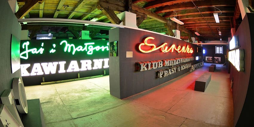 Neon museum with neon lighting signages on the wall, lights hanging and a wooden ceiling