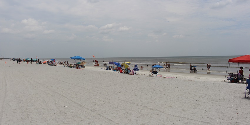 A very busy beach with families chilling on the best beach in Jacksonville, Florida.