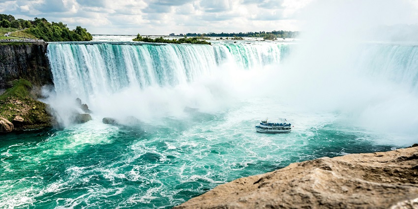 Spectacular view of the iconic Niagra Falls with a glimpse of the Rainbow Bridge.