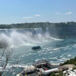 An image of Niagara Falls cascading powerfully with mist rising, viewed from the Ontario side, Canada