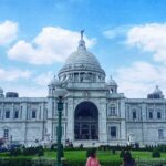 The vast white structure of Victoria Palace in Kolkata with a dome and large towers.