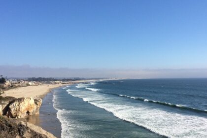 Slow waves are gradually coming to the golden sand, surrounded by rocky highlands