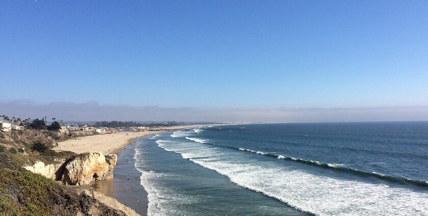 Slow waves are gradually coming to the golden sand, surrounded by rocky highlands