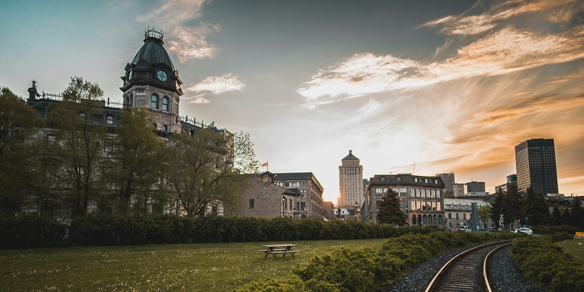 A picture of the scene of a place full of historic buildings, cobblestone roads, and more.