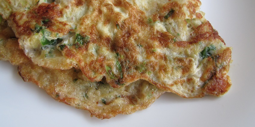 Fluffy omelette loaded with veggies, served with fresh bread.