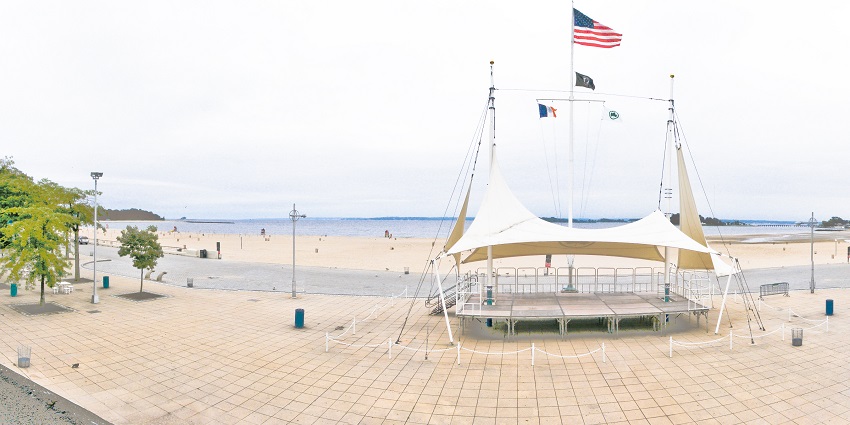 A wide-angle view of one of the best beaches near New York with a white canopy standing