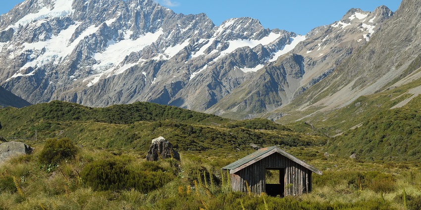 A cute hut awaits the weary traveler near the Mount Aoraki range.