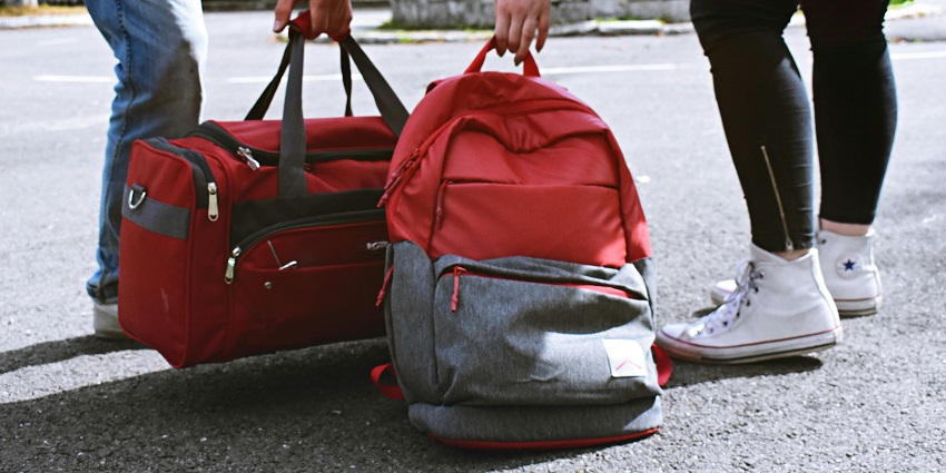 An image showing visitors with bags and backpacks, carrying their travel essential items
