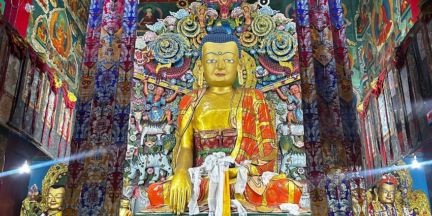 A beautiful golden statue of Buddha amidst colourful architecture, one of the things to see on a trip to Darjeeling.