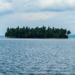 An image of an Island in Panama with clear blue water, sandy beaches, and rich green vegetation.