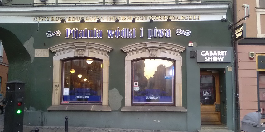 Outside of Pijalnia Wódki i Piwa bar with a couple of windows and signage on the wall.