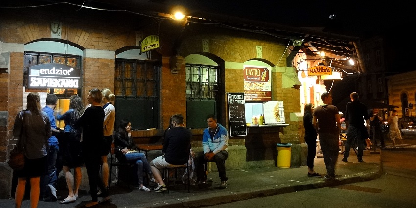 Street of Plac Nowy with the people outside the pubs and buying drinks from the counter
