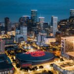 Downtown Houston at night with well-lit skyscrapers and a Toyota Center in the middle