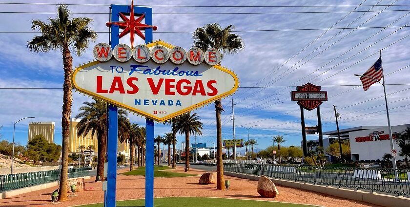 A sign board with Welcome to Fabulous Las Vegas written on it and palm trees behind