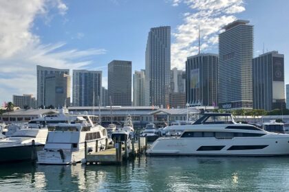 View of the lower Miami skyline with tall buildings and yachts anchored on Bayfront Park.