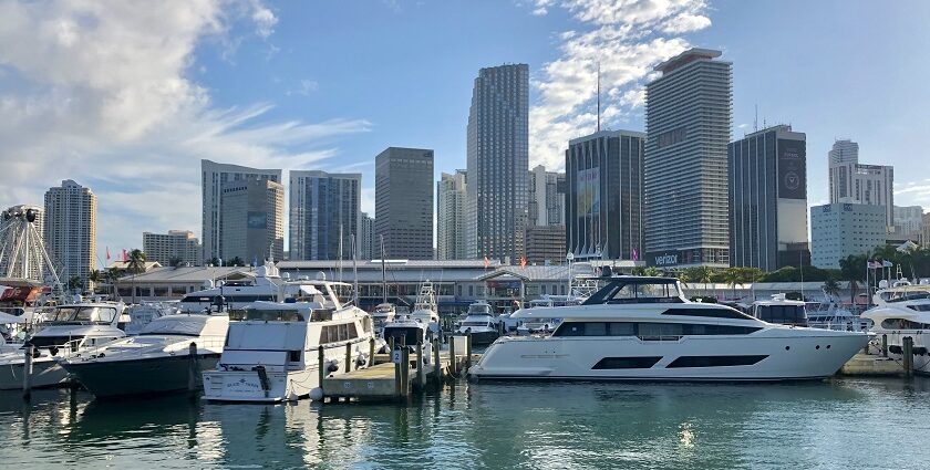 View of the lower Miami skyline with tall buildings and yachts anchored on Bayfront Park.