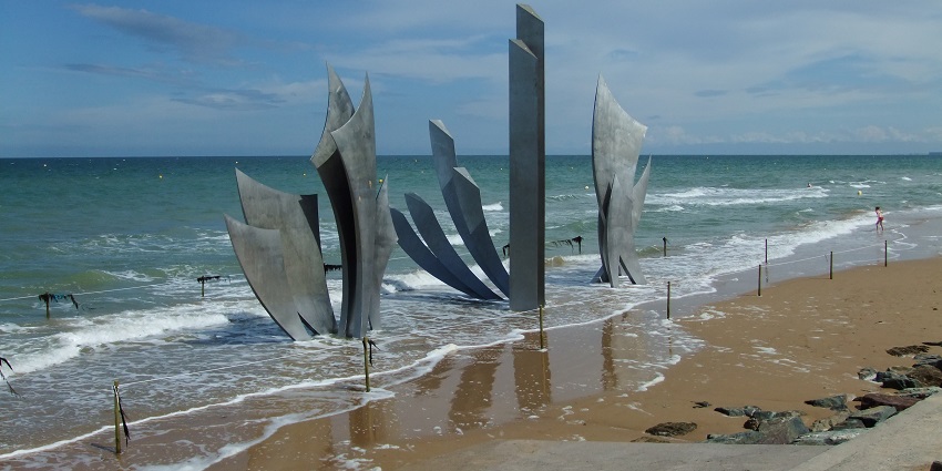Historic D-Day landing site with vast stretches of sandy shores.