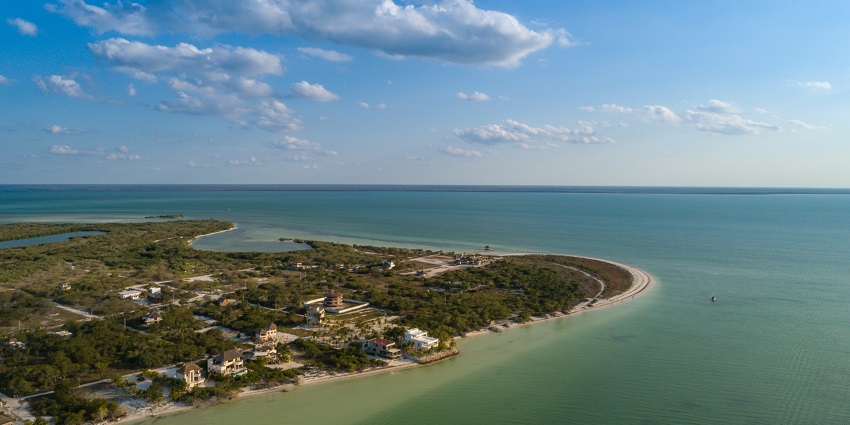 An aerial view of Playa Tortuga and Punta Cocos on Isla Holbox, featuring clear turquoise waters