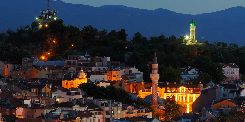 Plovdiv at night with a monument and vibrant buildings well lit with colourful lights