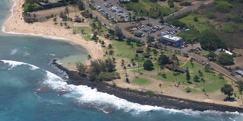 Aerial view of Poipu Beach Park in Kauai, showcasing its sandy shores and clear blue waters.