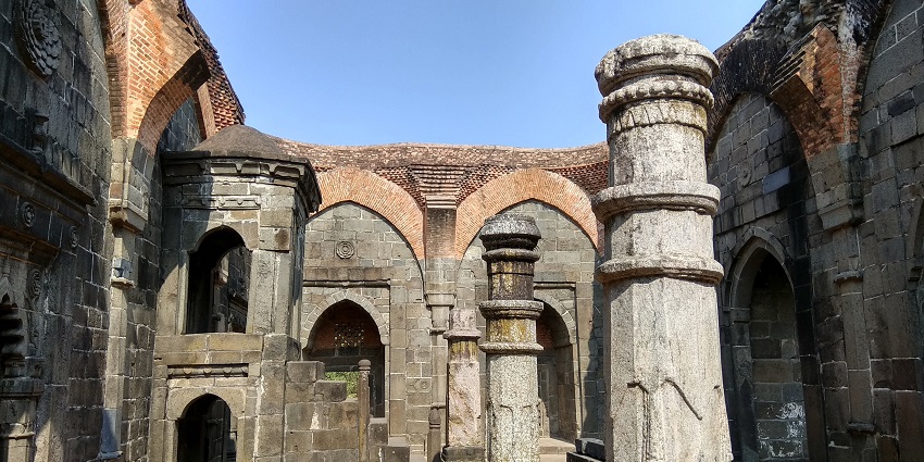 A picture of the ancient stone structure of Adina Mosque, has arched doorways
