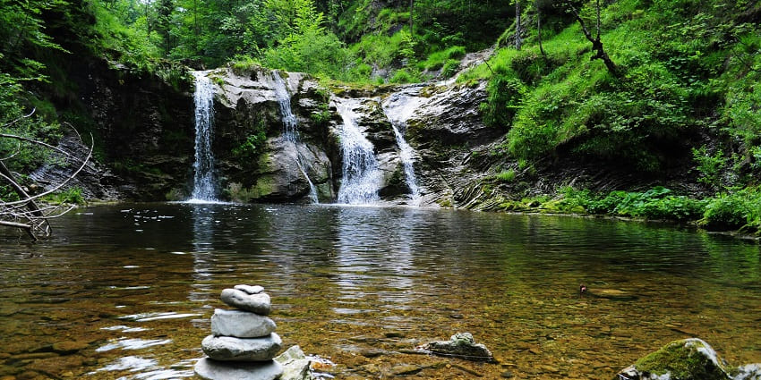 A picture of Rautwadi Waterfall near Dajipur, surrounded by dense greenery.