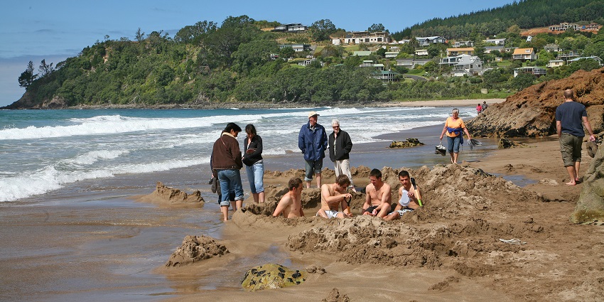 Tourists enjoying at Hot Water Beach, a fun thing to do in New Zealand
