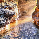 A beautiful picture of the Robbers Cave with a narrow gorge and streams.