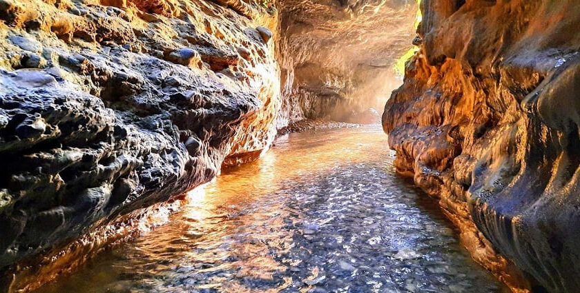 A beautiful picture of the Robbers Cave with a narrow gorge and streams.