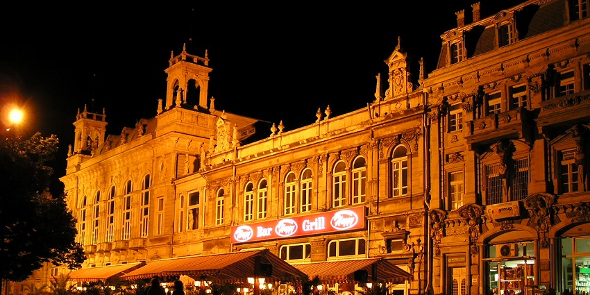 Ruse with traditional-style buildings, restaurants and people standing near street lights