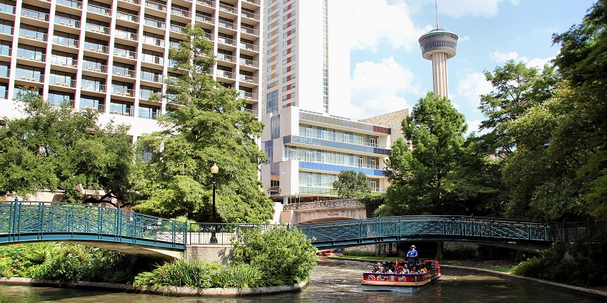 The picture of the San Antonio River Walk with the Tower of the Americas in Texas.