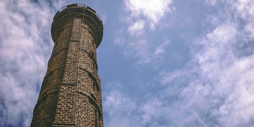 View of the four-storied red-brick Satkhanda tower in Lucknow, blending Mughal and Gothic styles.