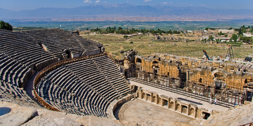 Majestic Hierapolis Theatre with grand stone seating and scenic mountain backdrop.