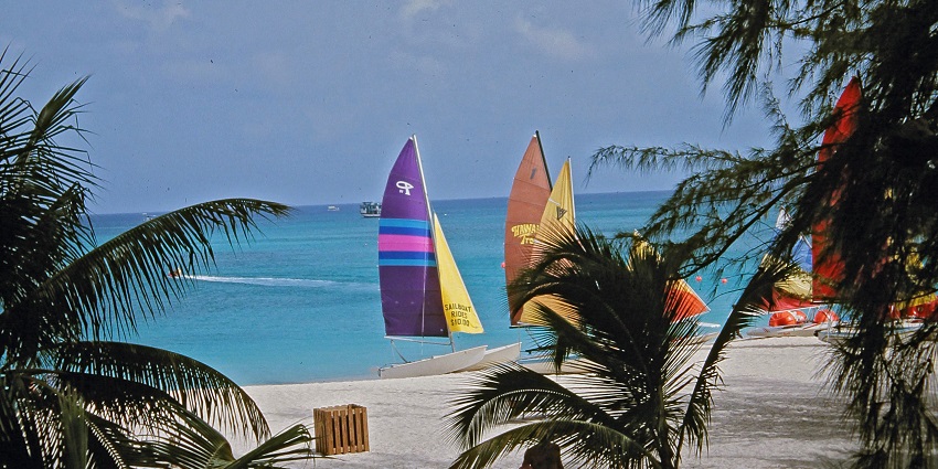 A picture of the beautiful Seven Mile beach with sailboats on the shore