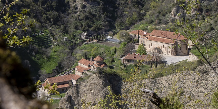 Peaceful monastery nestled in a cave with scenic surroundings.