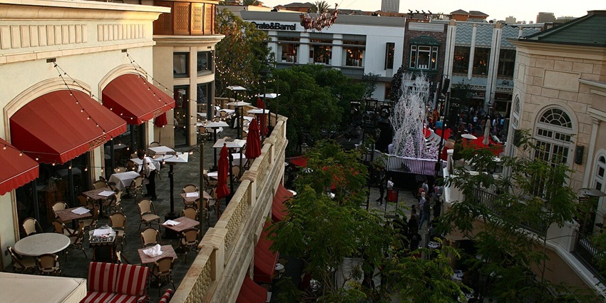 The Grove with rooftop restaurant seating area and other buildings surrounded by greenery